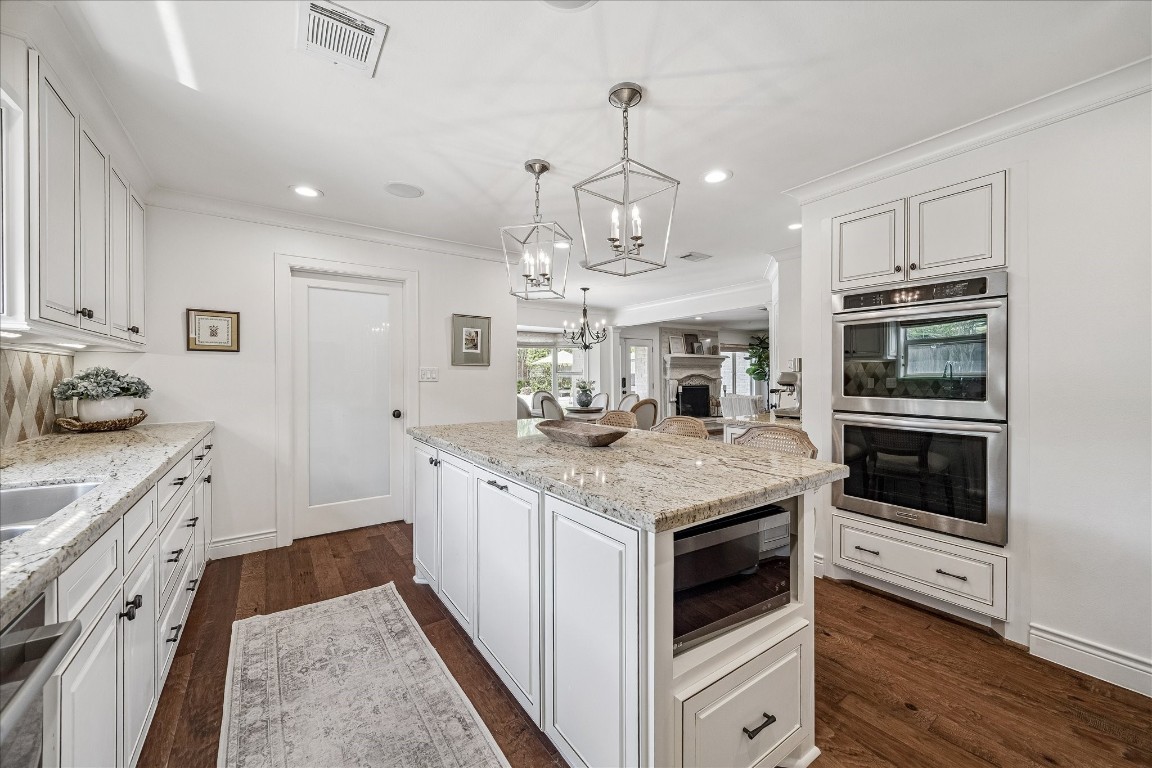 627 Ramblewood Road Houston, TX 77079 - Photo 13 of 48 Gourmet kitchen has Kitchen Aid double ovens, gas cook top, designer lighting and wood floors.