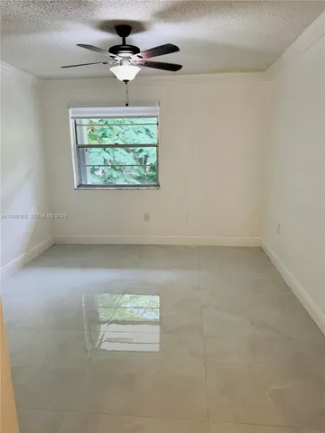 an empty room with a window and a ceiling fan
