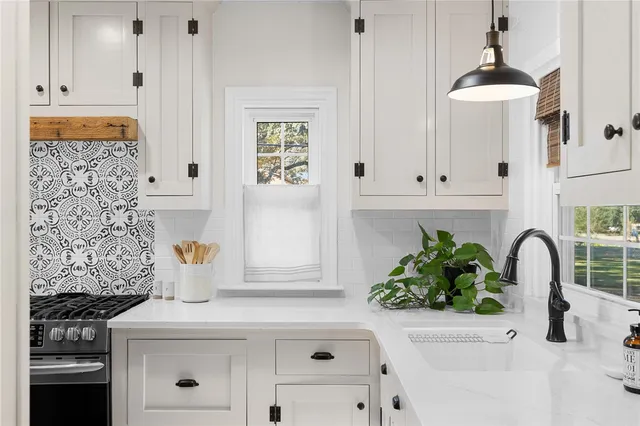 a kitchen with cabinets appliances and a window