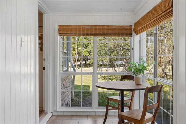 a living room with stainless steel appliances furniture a rug and a window