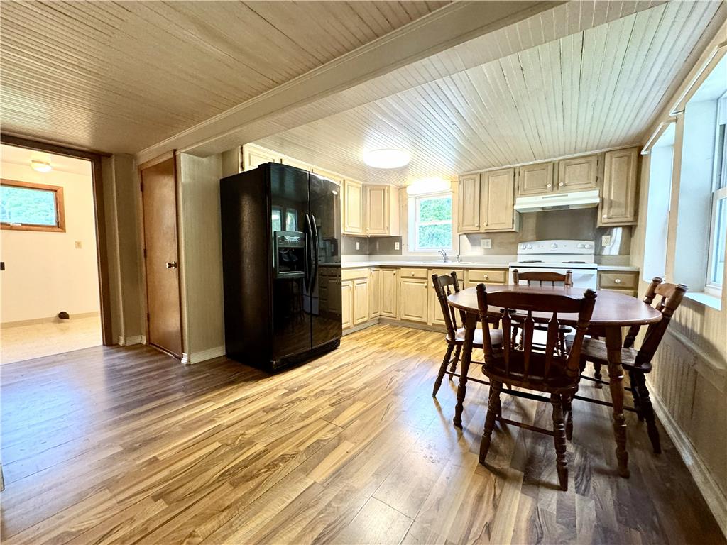 Warm wood flooring and classic wood-paneled ceilings define this country kitchen space.