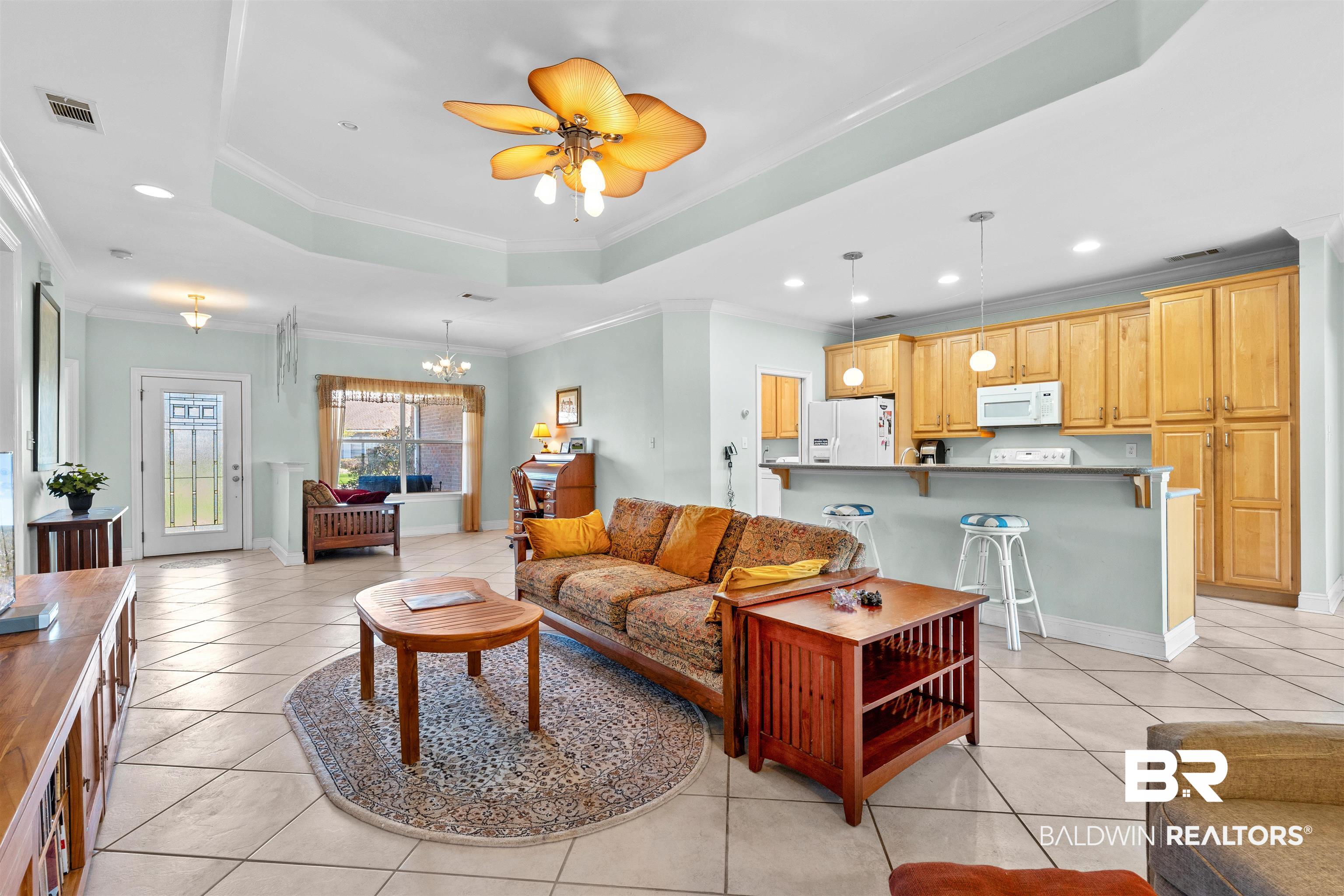 237 Hemingway Loop Foley, AL 36535 - Photo 4 of 49 Living room with a tray ceiling, light tile patterned floors, and ornamental molding