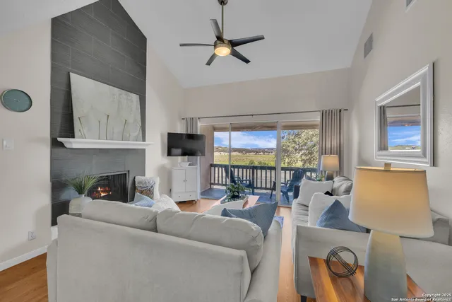 a living room with furniture a ceiling fan and a window