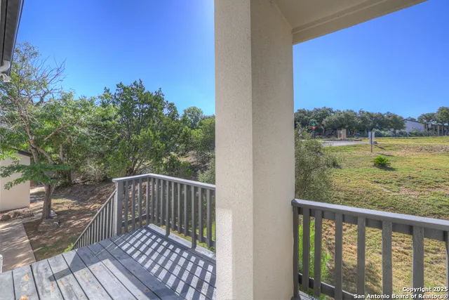 a view of a balcony with wooden floor and fence