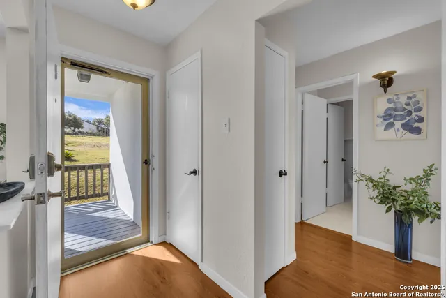a view of a hallway with wooden floor and a potted plant