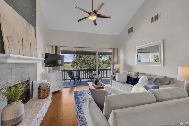 a living room with furniture a fireplace and a floor to ceiling window