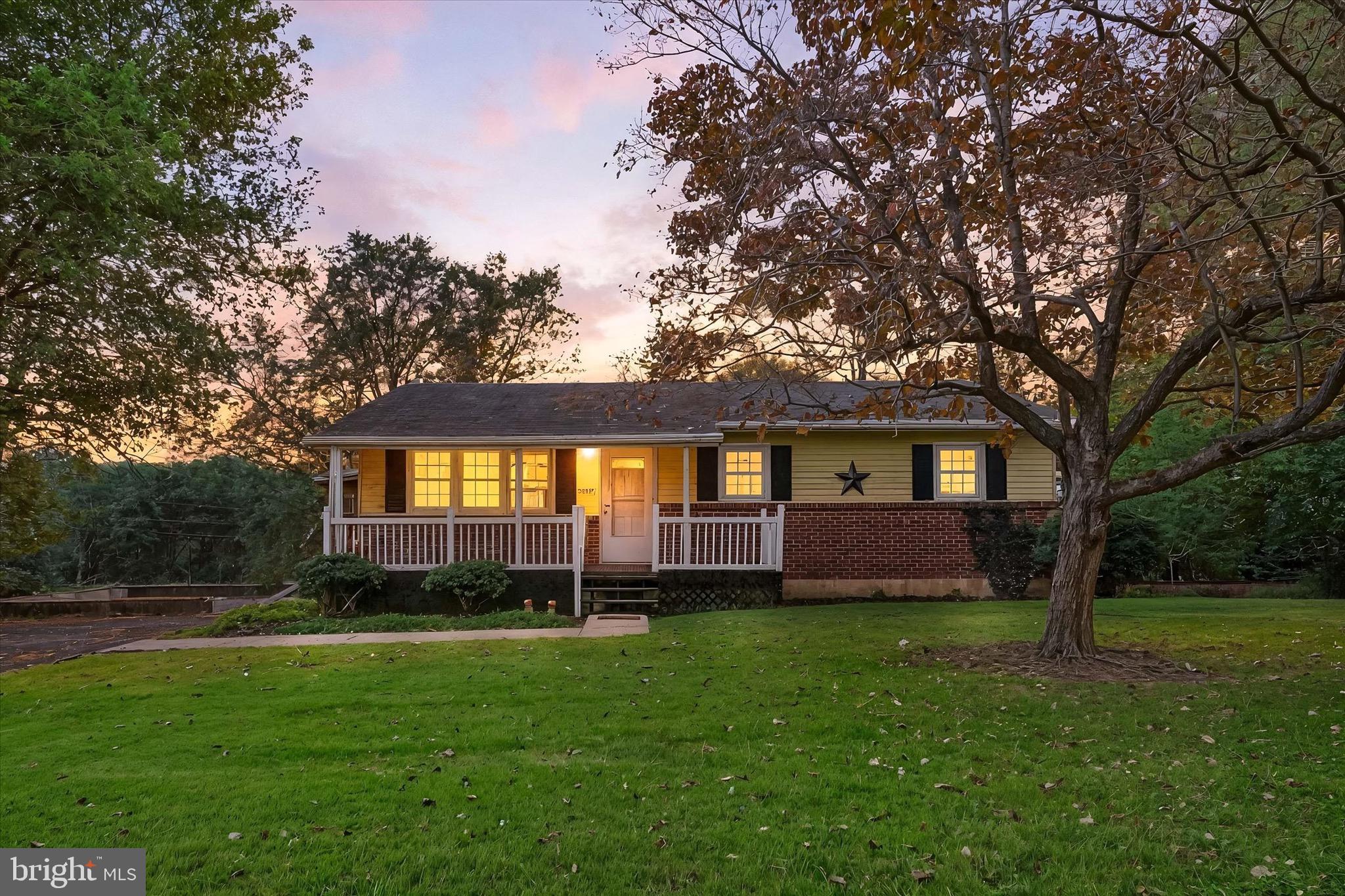 a front view of a house with a garden and trees