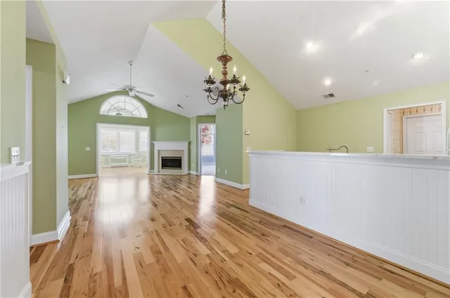 a view of a hallway with wooden floor and a chandelier