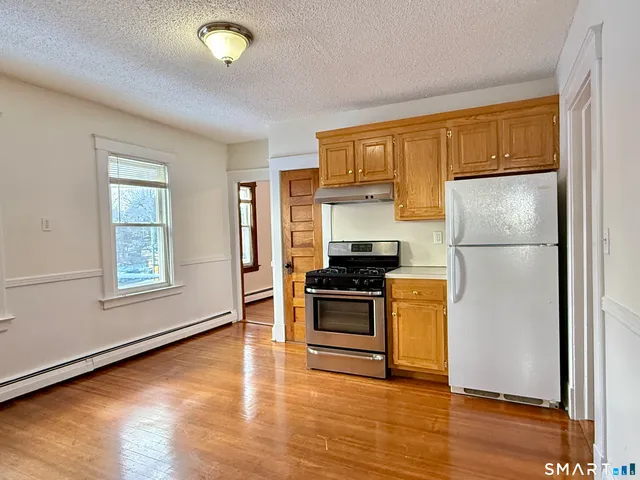 a kitchen with a refrigerator and a stove top oven