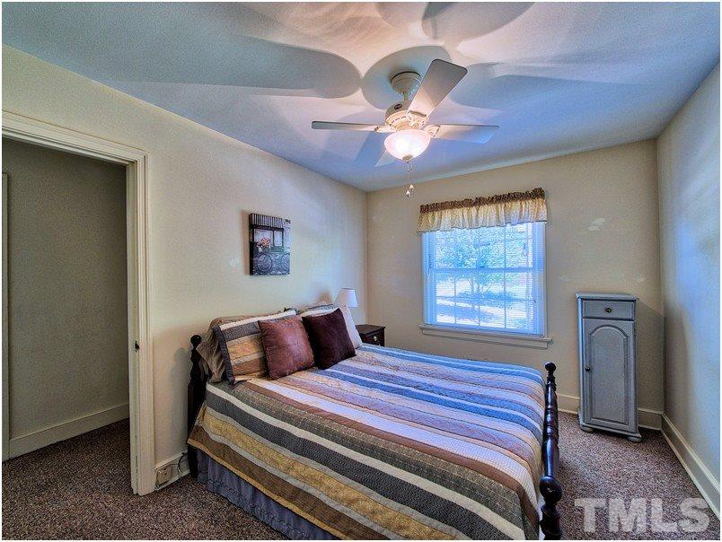 2703 Clark Avenue Raleigh, NC 27607 - Photo 11 of 24 a bedroom with a bed and a chandelier