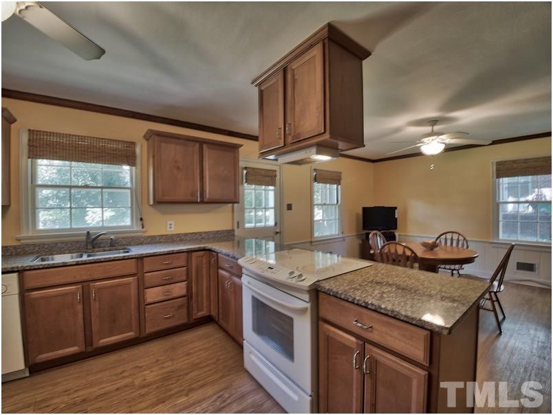 2703 Clark Avenue Raleigh, NC 27607 - Photo 4 of 24 a kitchen with granite countertop kitchen island stainless steel appliances a sink stove and cabinets