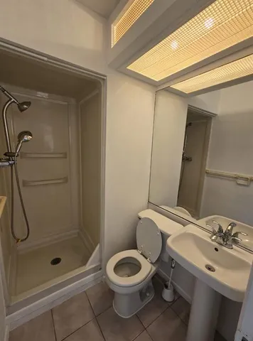 a bathroom with a shower a toilet and a sink