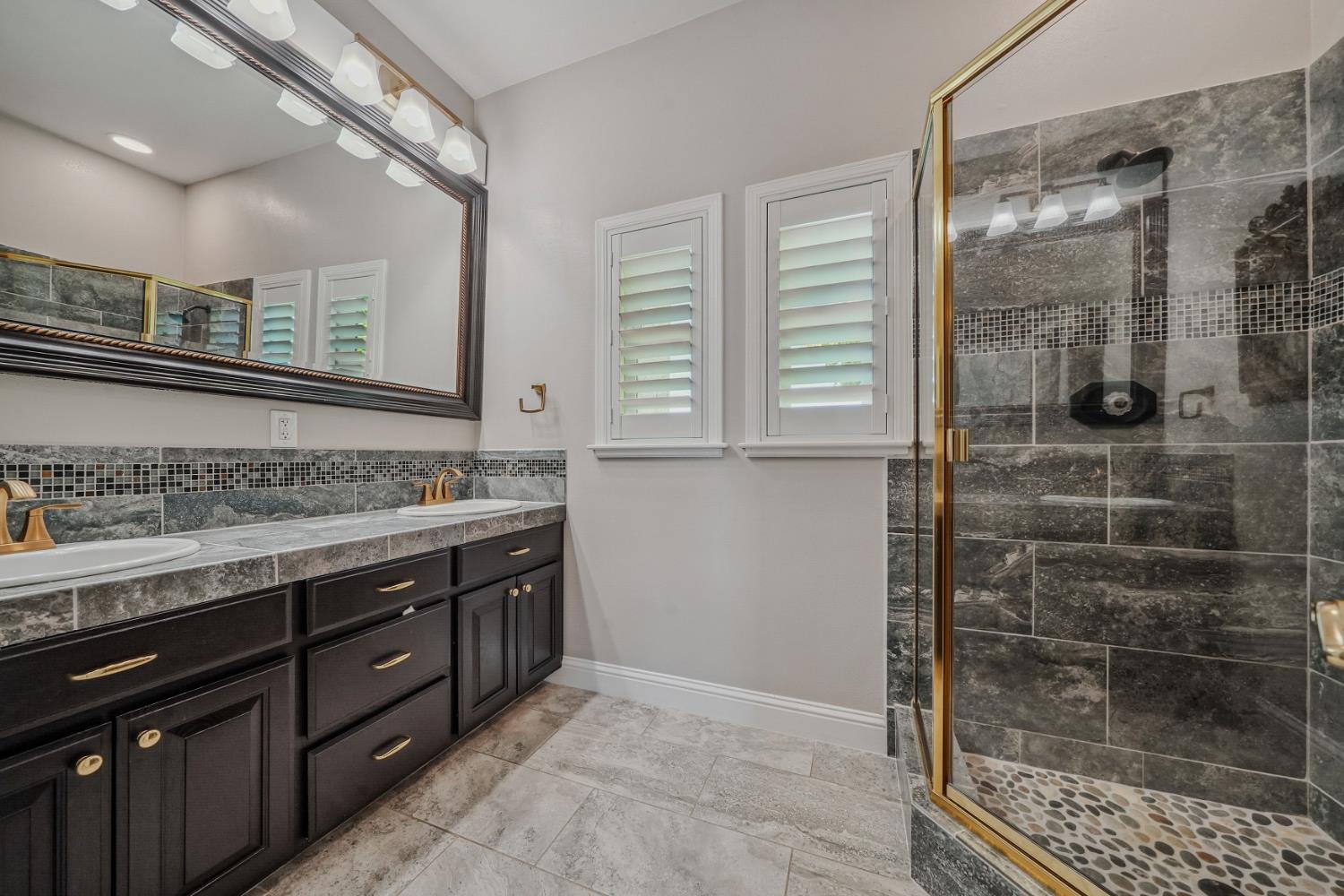 10786 Shenandoah Road Plymouth, CA 95669 - Photo 41 of 80 a bathroom with a granite countertop sink a mirror and shower
