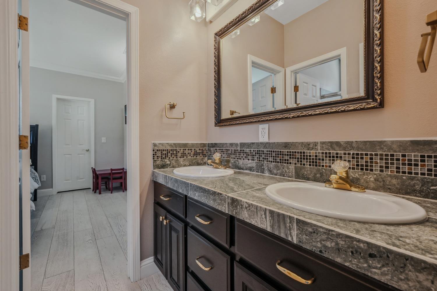 10786 Shenandoah Road Plymouth, CA 95669 - Photo 44 of 99 a bathroom with a granite countertop sink a mirror and a