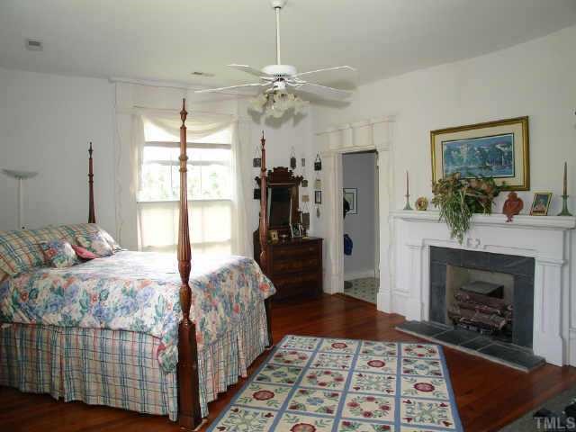 4840 Solomon Lea Road Leasburg, NC 27291 - Photo 6 of 10 a bedroom with a bed and a fireplace
