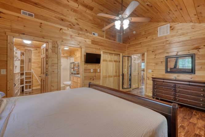 130 Coopers Ridge Road Murphy, NC 28906 - Photo 22 of 32 a bedroom with a bed and a chandelier