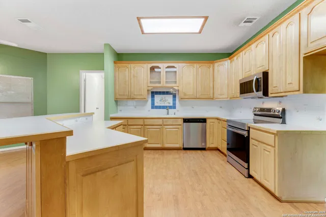 a kitchen with stainless steel appliances a stove sink microwave and cabinets