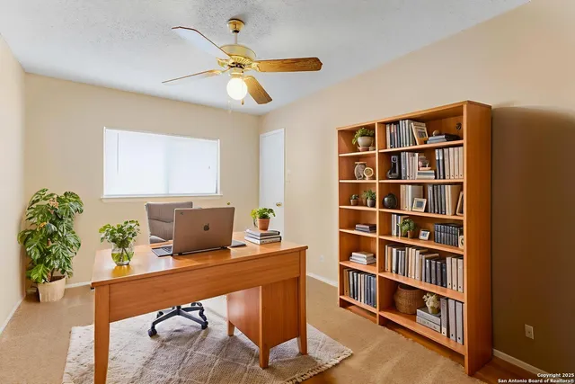 an empty room with a window and a chandelier fan