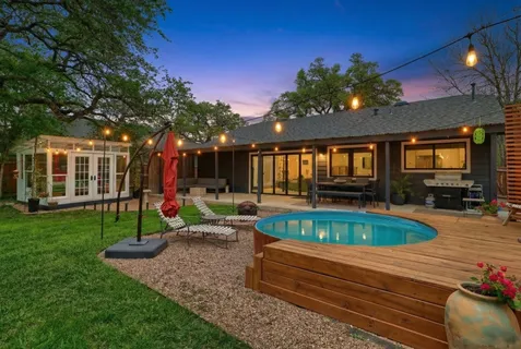 a view of a house with backyard swimming pool and sitting area