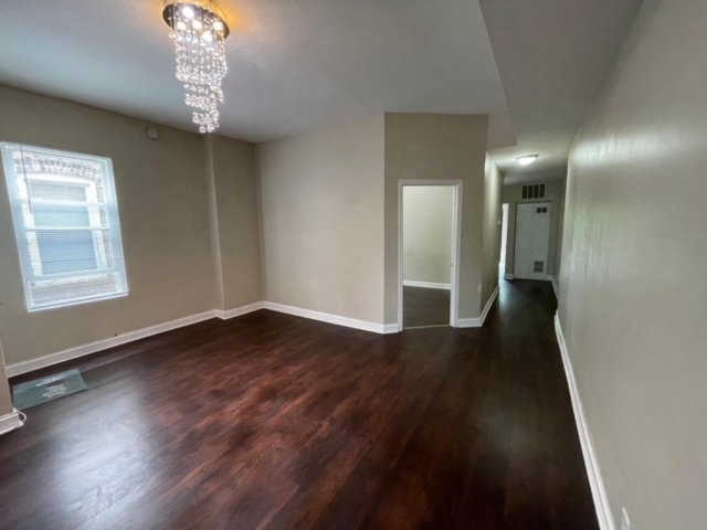 5616 South Indiana Avenue, Unit 2 Chicago, IL 60637 - Photo 2 of 14 an empty room with wooden floor and windows