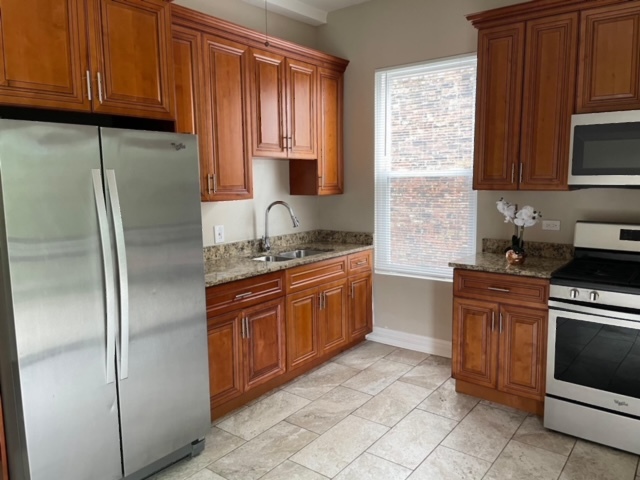 5616 South Indiana Avenue, Unit 2 Chicago, IL 60637 - Photo 9 of 14 a kitchen with stainless steel appliances granite countertop a refrigerator sink and cabinets