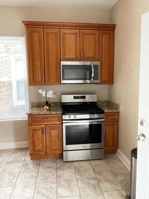 5616 South Indiana Avenue, Unit 2 Chicago, IL 60637 - Photo 10 of 14 a kitchen with granite countertop a stove top oven microwave and cabinets