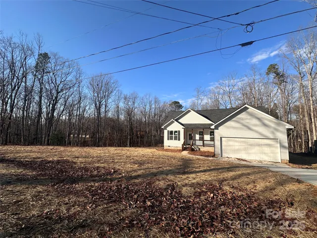 a front view of a house with a yard and trees