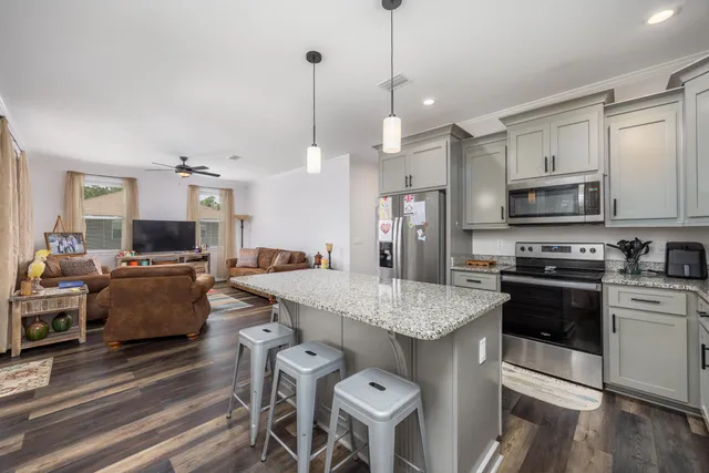 a large kitchen with kitchen island white cabinets and stainless steel appliances