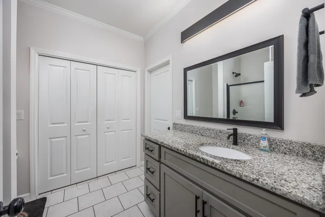 a bathroom with a granite countertop double vanity sink and a mirror
