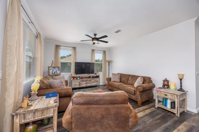 a living room with furniture a flat screen tv and a window