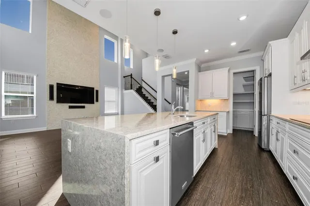 a room with wooden floor pool table and windows