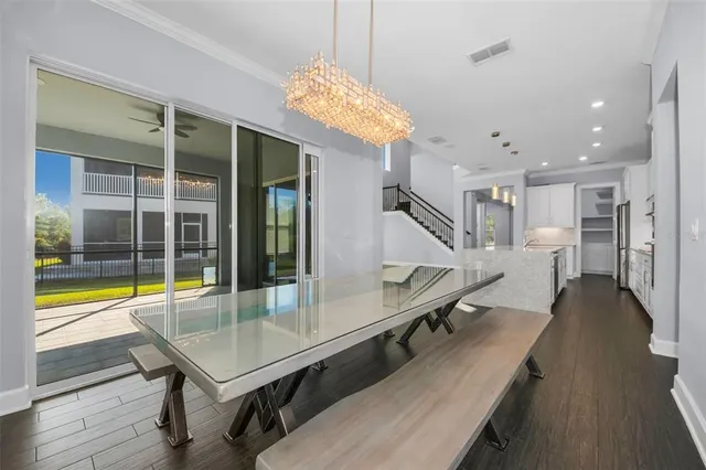 a view of an empty room with wooden floor and a chandelier