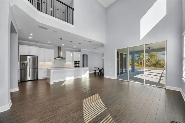 a view of a kitchen with a sink a ceiling fan and stainless steel appliances