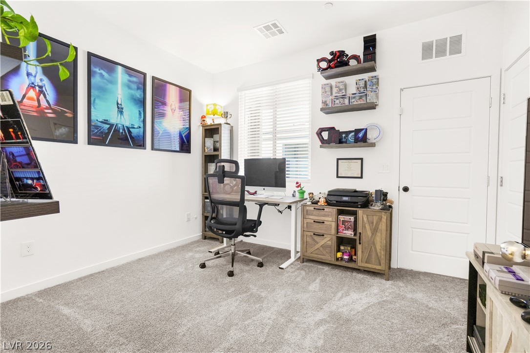 9398 Noble Fir Rdg Court Las Vegas, NV 89143 - Photo 26 of 36 A well-lit study with plush carpet flooring offers a quiet retreat for productivity.