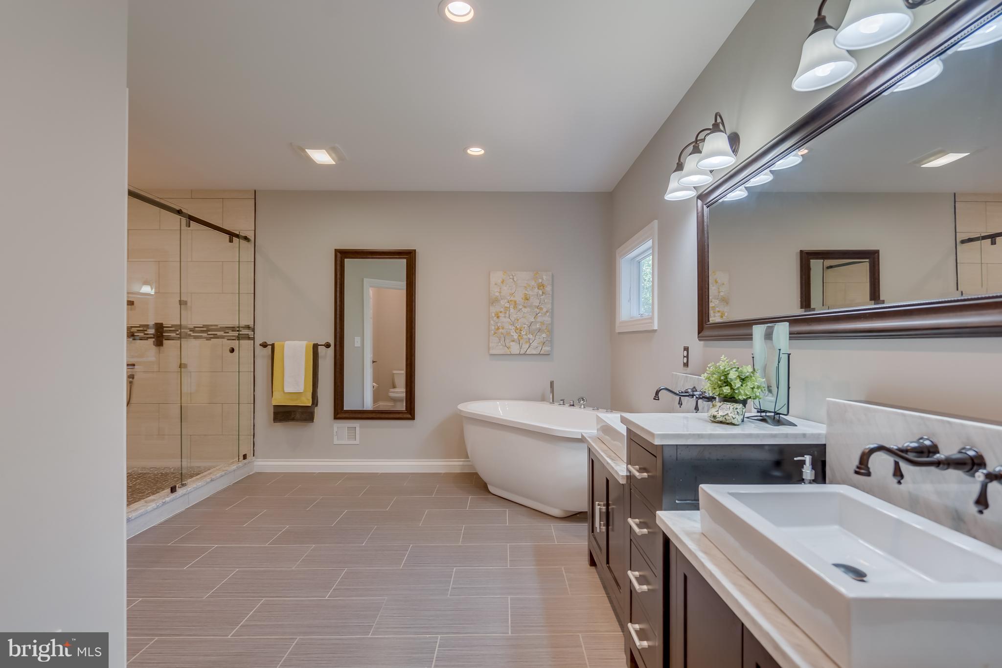 1415 Julia Avenue McLean, VA 22101 - Photo 13 of 30 a spacious bathroom with a double vanity sink a mirror and a shower