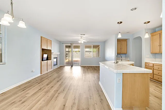 a view of a kitchen and empty room with wooden floor and a kitchen