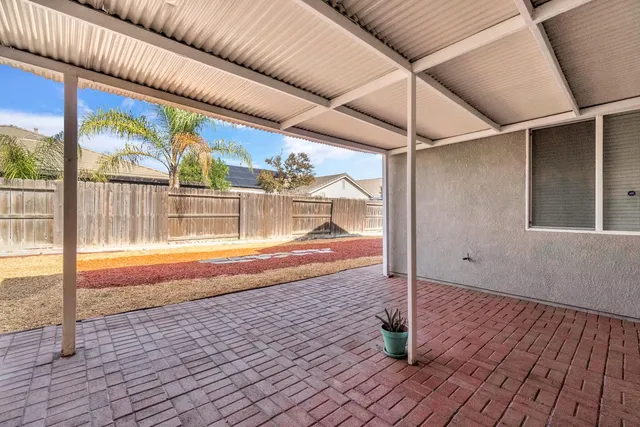 a view of house with backyard and ceiling fan