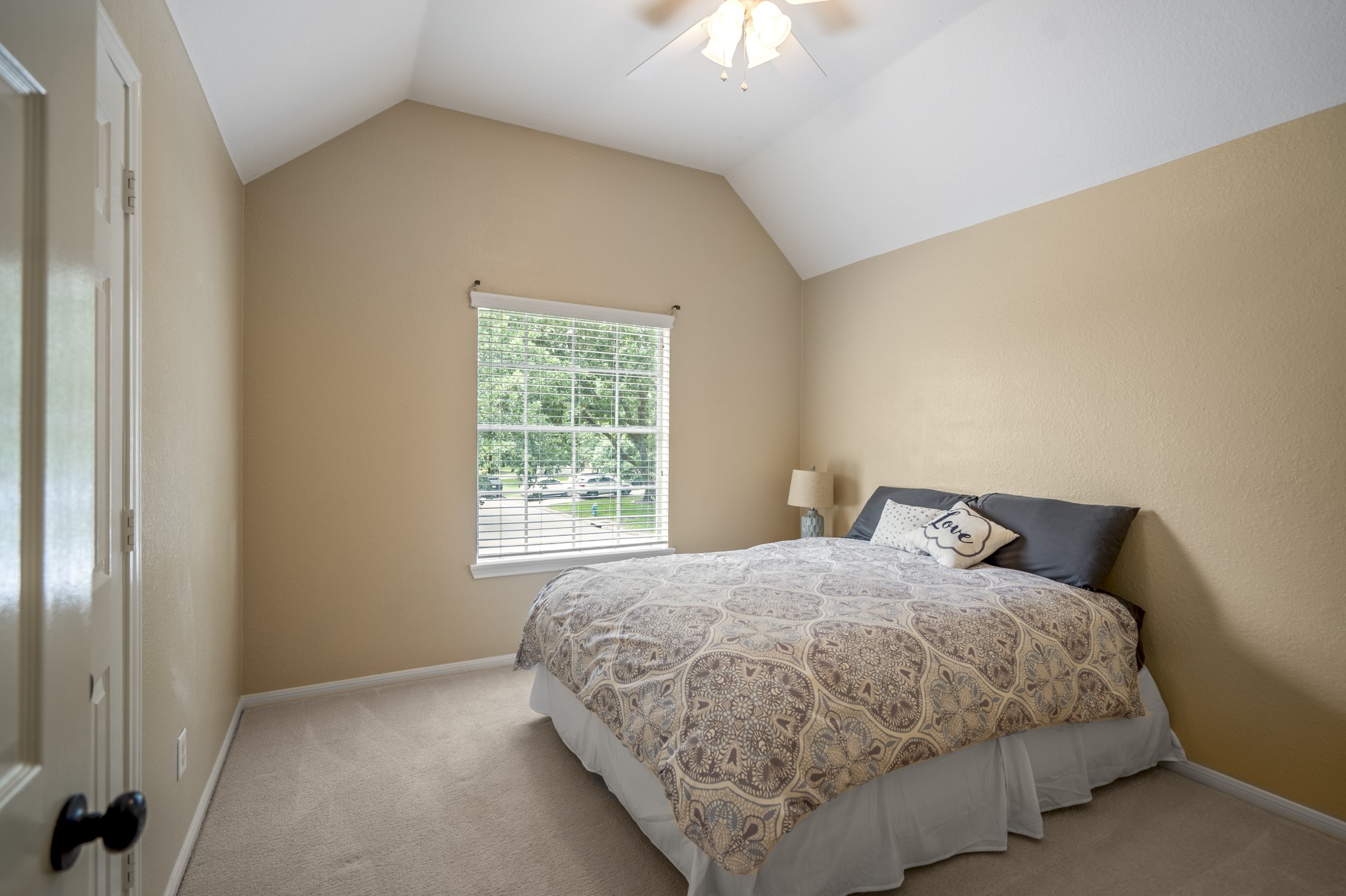 5835 Pinelake Crossing Drive Spring, TX 77379 - Photo 27 of 50 The second upstairs bedroom overlooks the front of the home and features a vaulted ceiling that adds to the sense of space. Conveniently located near the game room and the hall bath (pictured later), it offers both comfort and easy access to shared living areas.