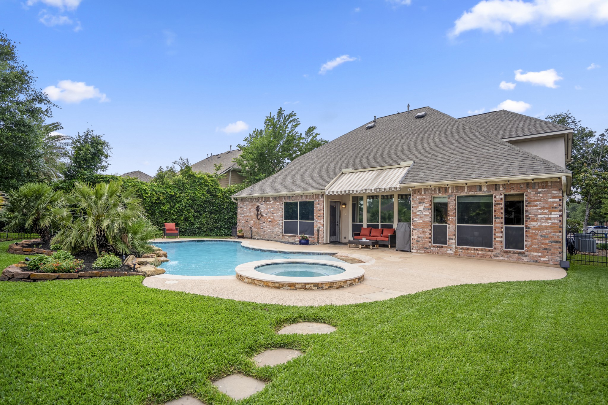 5835 Pinelake Crossing Drive Spring, TX 77379 - Photo 35 of 50 From this vantage point near the rear of the yard, you can see how the green space frames the pool and home, with a stretch of grass that adds room to play or unwind. Stepping stones guide you toward the back fence, tying the yard together while maintaining those open golf course views beyond.