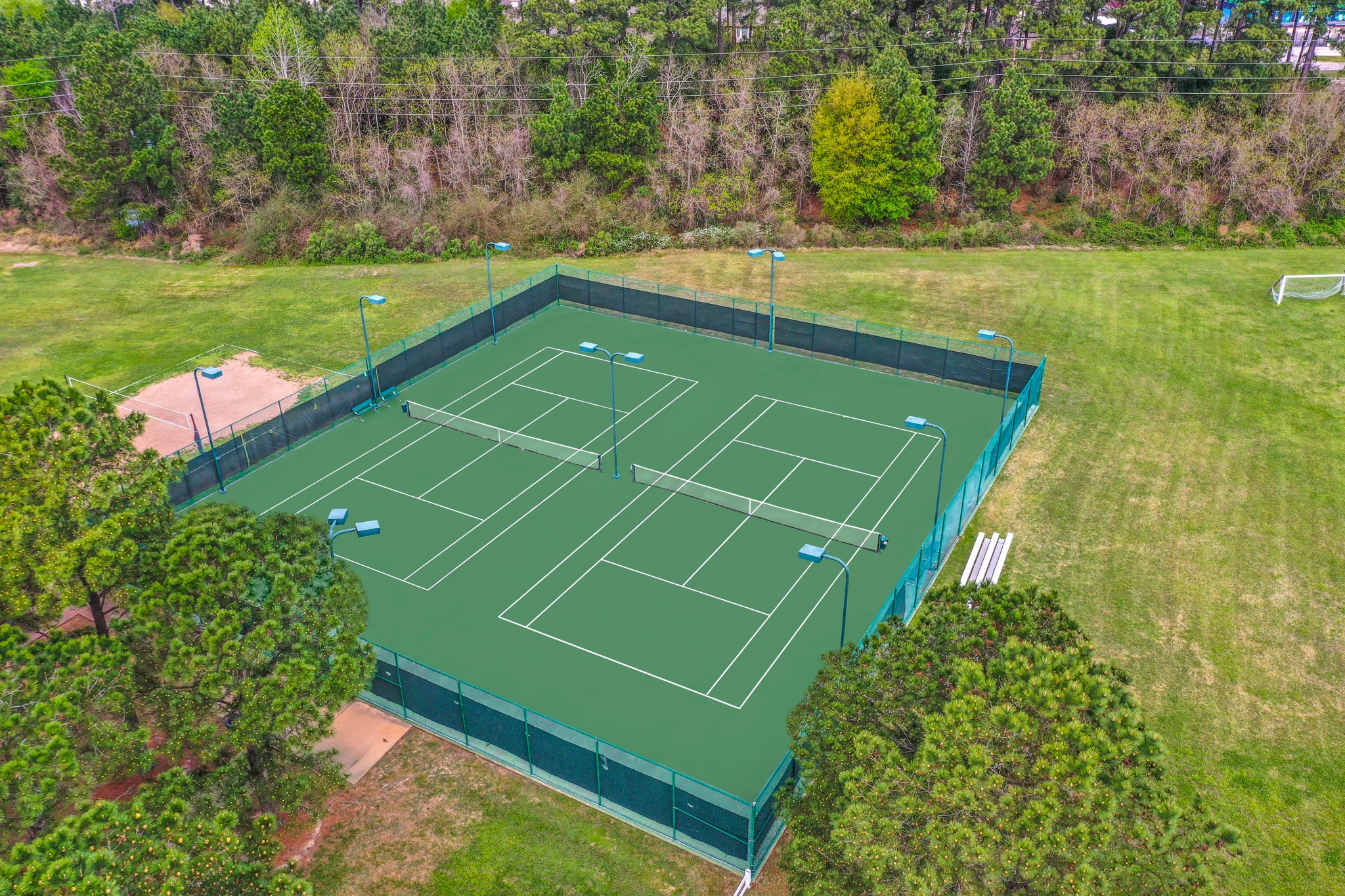 5835 Pinelake Crossing Drive Spring, TX 77379 - Photo 45 of 50 Enjoy an aerial view of our community tennis courts in Windrose, where residents can engage in friendly matches and stay active. Part of a vibrant community hub that also features pools, a Meeting House, and ample green space for all your recreational needs.
