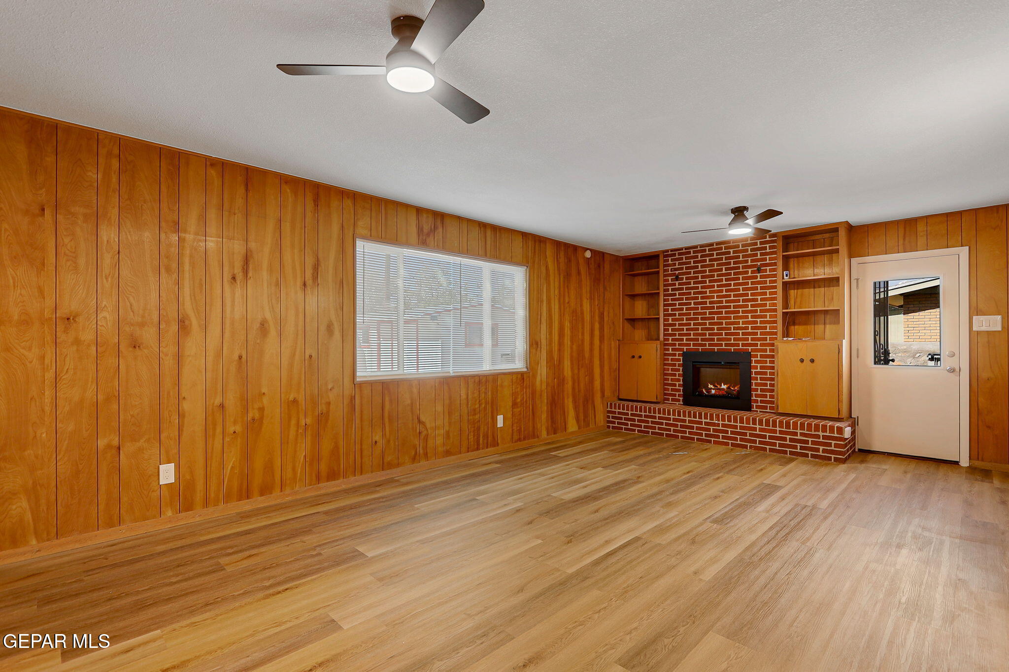 2801 Dunoon Drive El Paso, TX 79925 - Photo 14 of 41 an empty room with wooden floor fireplace and windows