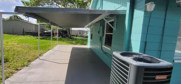 a backyard of a house with a swing table and chairs