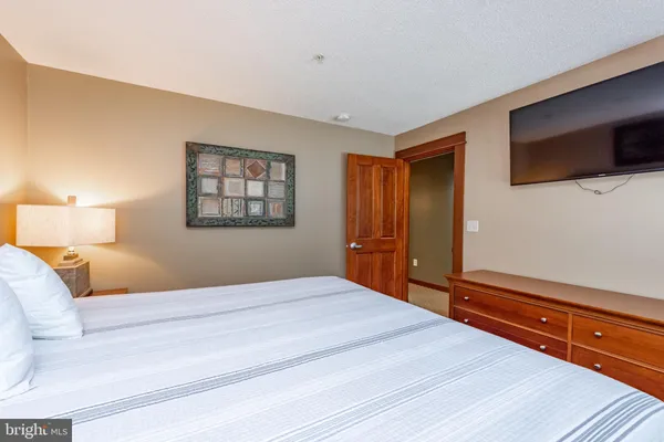 a bedroom with a large bed and a tv