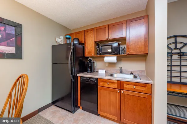 a kitchen with stainless steel appliances granite countertop a refrigerator a stove a sink and a microwave
