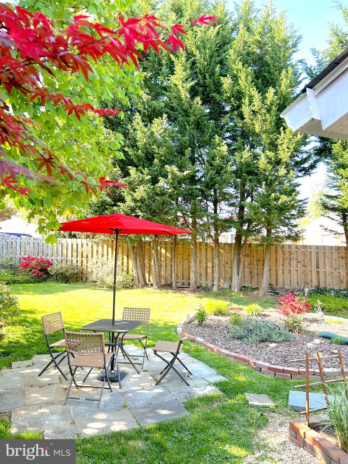 11504 Newport Mill Road Silver Spring, MD 20902 - Photo 36 of 41 a view of a backyard with a table and chairs under an umbrella