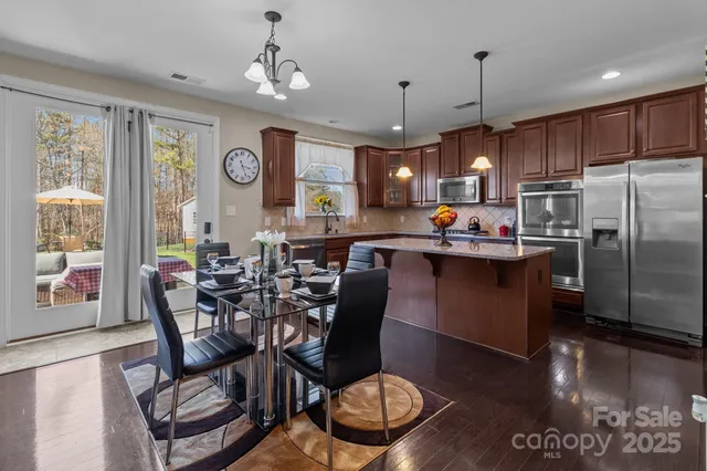 a dining table with a stove a kitchen island dining table and chairs