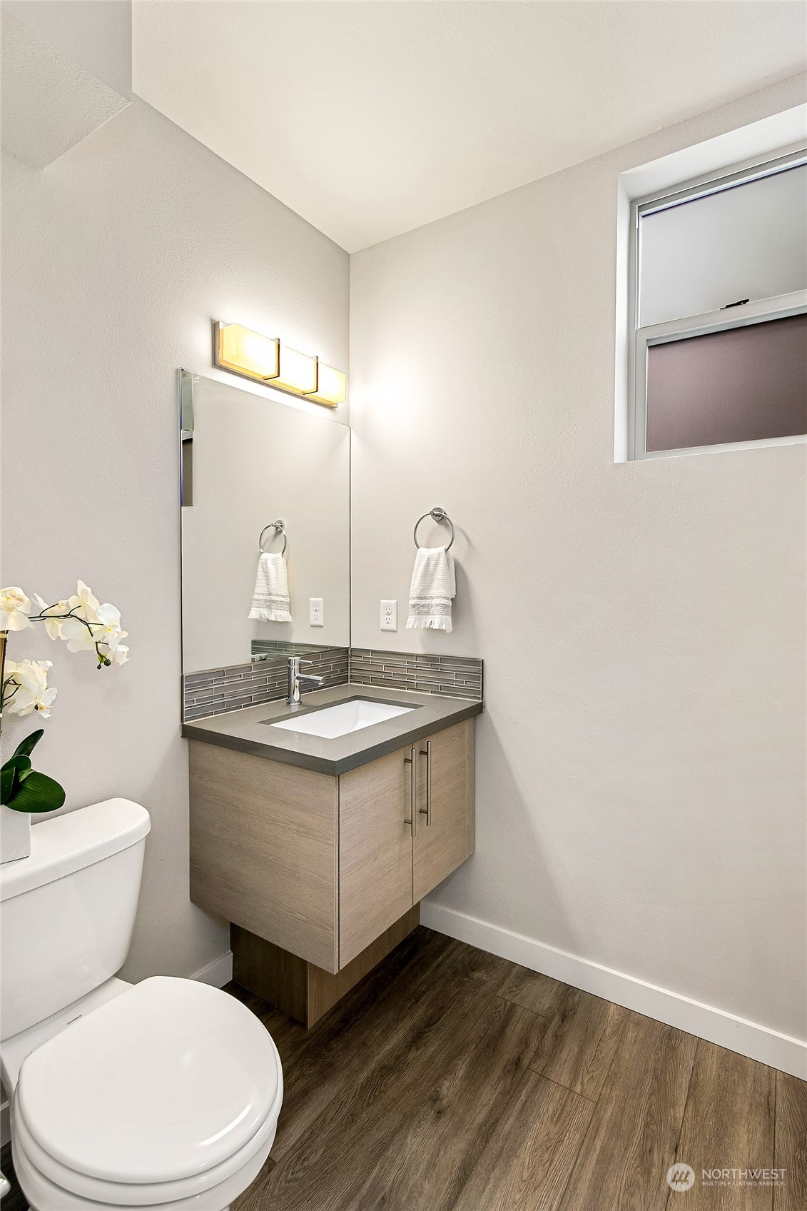 8435 22nd Avenue Southwest Seattle, WA 98106 - Photo 13 of 22 a bathroom with a granite countertop toilet a sink and a mirror