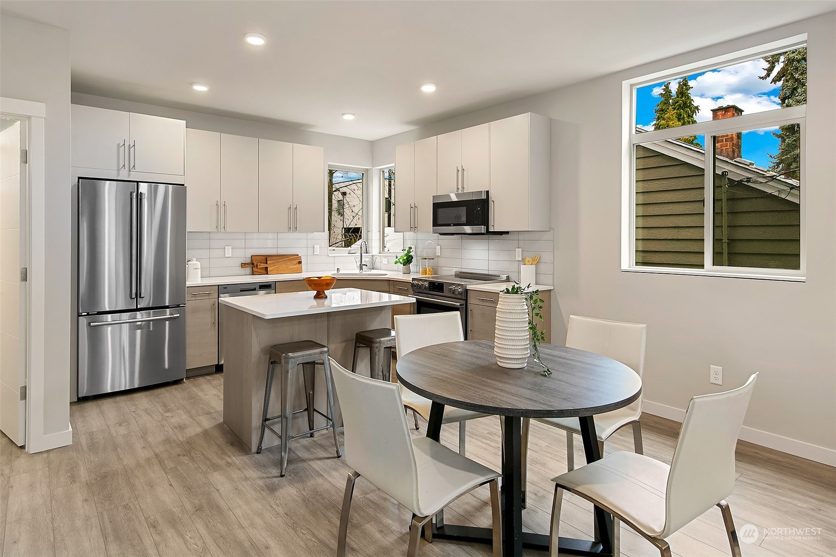 8435 22nd Avenue Southwest Seattle, WA 98106 - Photo 3 of 22 a kitchen with stainless steel appliances a dining table chairs stove refrigerator and microwave