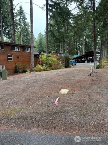 a view of a street with trees and cars parked