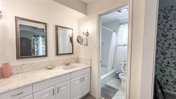 a bathroom with a granite countertop sink mirror and a toilet